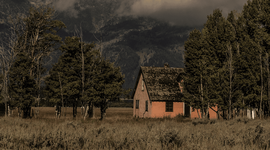 Tijdloos huisje op de prairie met bergen in de achtergrond
